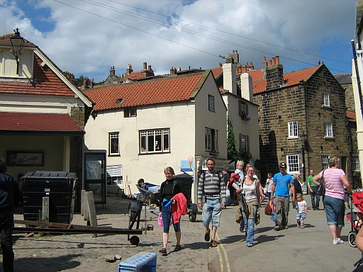 Tourists and holidaymakers at the bottom of the steep road in Robin Hoods Bay